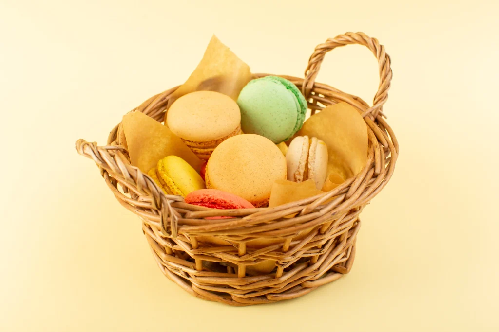 front-view-colorfula-french-macarons-inside-basket-yellow-desk-biscuit-cake-sugar-sweet